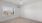 An empty bedroom with a window and ceiling fan