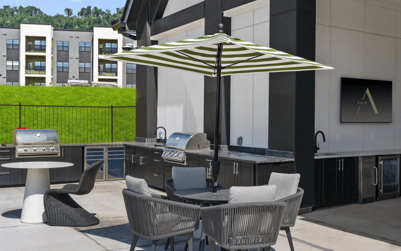 tables outside next to a grill 