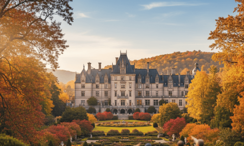 The Biltmore House framed by colorful fall foliage under a crisp autumn sky.