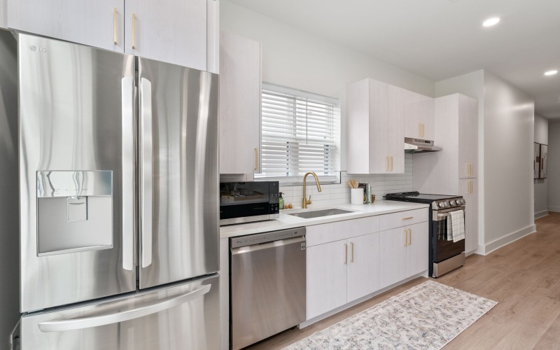 Kitchen with fridge, dishwasher, and window over sink